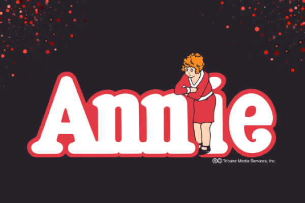 Annie logo on black backrground with red sparkles coming from top corners